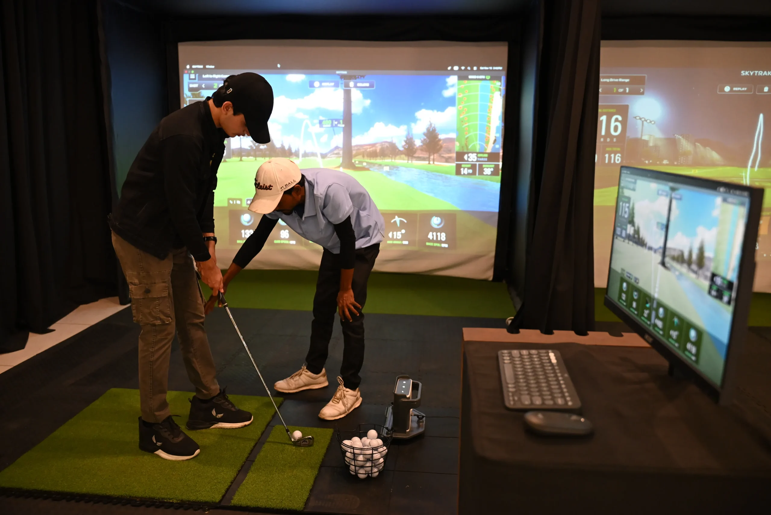 Interior view of SwingSpace indoor golf facility in Bhopal showing a virtual golf bays with simulators and a player with a coach.Interior view of SwingSpace indoor golf facility in Bhopal showing a virtual golf bays with simulators and a player with a coach.